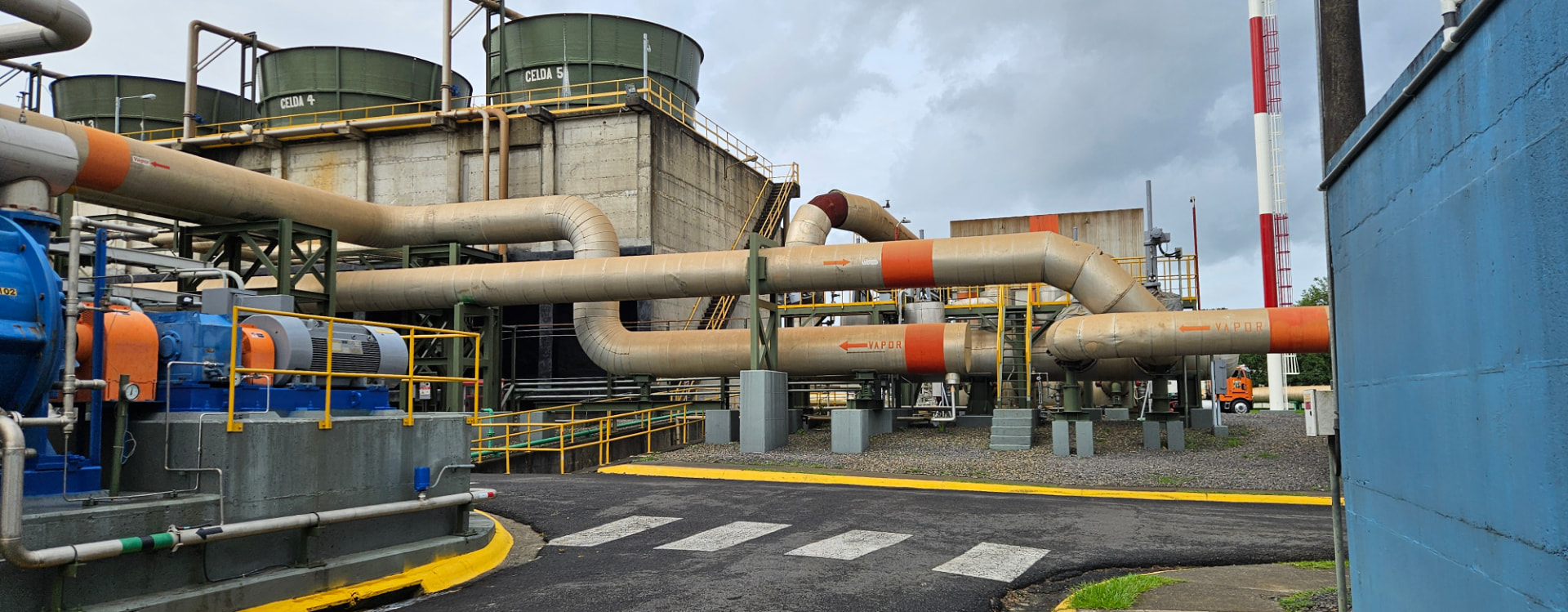 Instalación industrial con tuberías de vapor, motores y estructura de proceso