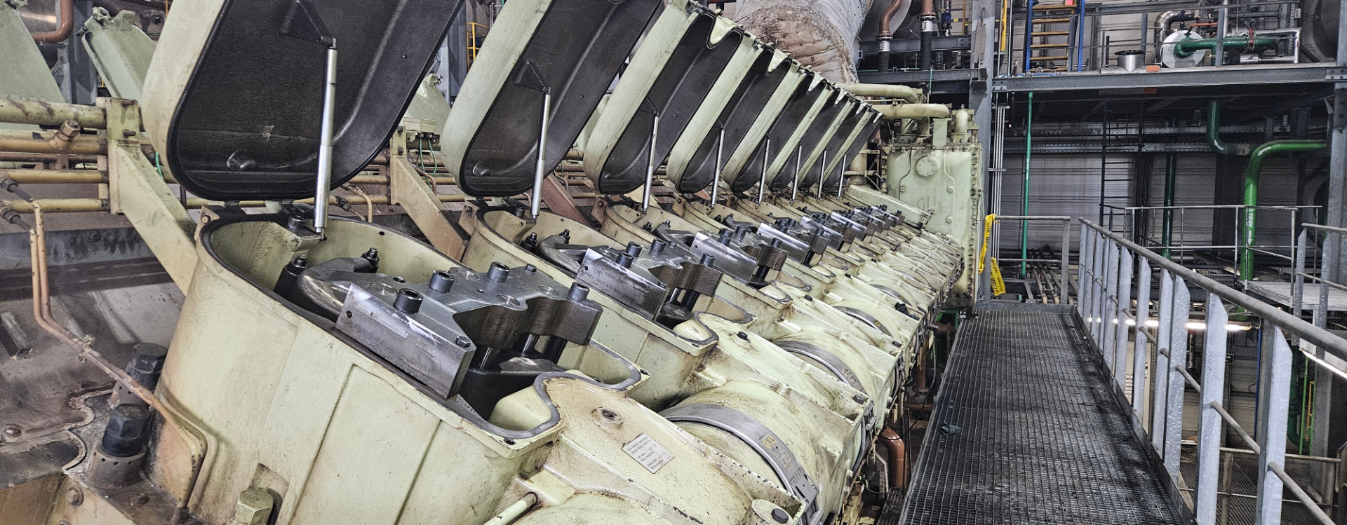 Motor industrial multicilindro con las tapas de válvulas abiertas durante mantenimiento